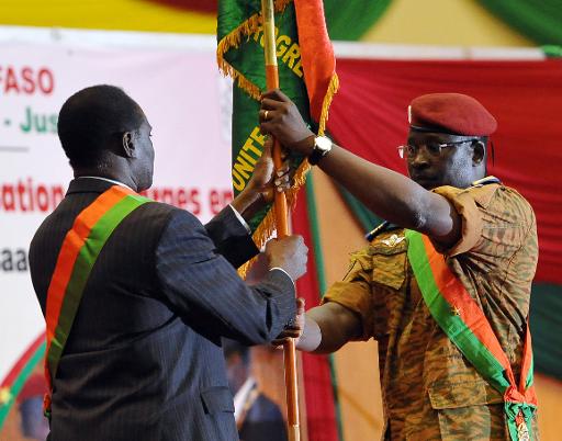 voir le zoom : Le lieutenant-colonel et Premier ministre Isaac Zida remet le drapeau du Burkina Faso à Michel Kafando, président par intérim, lors de la cérémonie d'investiture, le 21 novembre 2014 à Ouagadougou